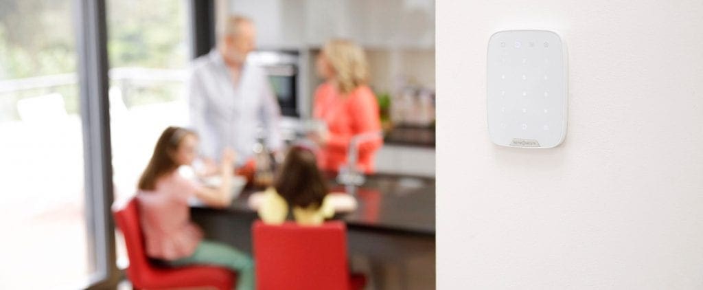alarm system keypad on wall family in kitchen